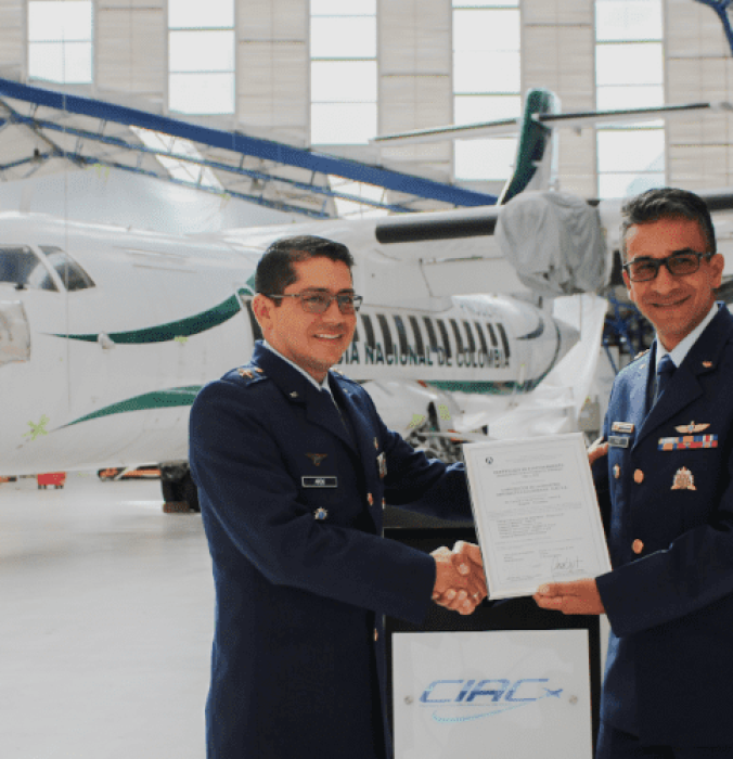 Un ex- gerente de CIAC recibiendo una certificación de la Aeronáutica Civil frente a una aeronave ATR 42