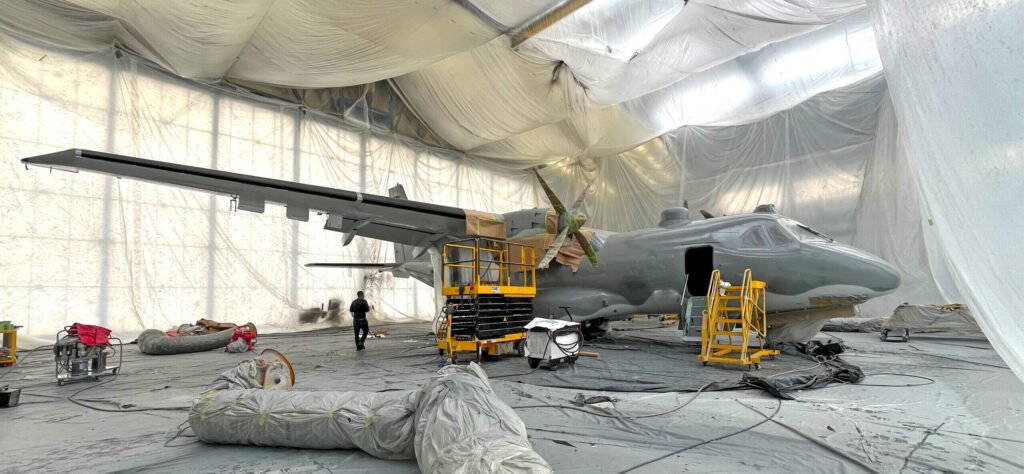 AERONAVE CN 235 EN CABINA DE PINTURA TEMPORAL EN EL HANGAR CIAC